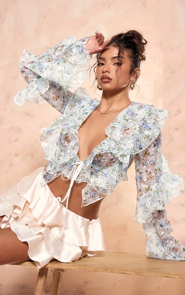 Blouse courte tissée bleue transparente fleurie nouée à volants