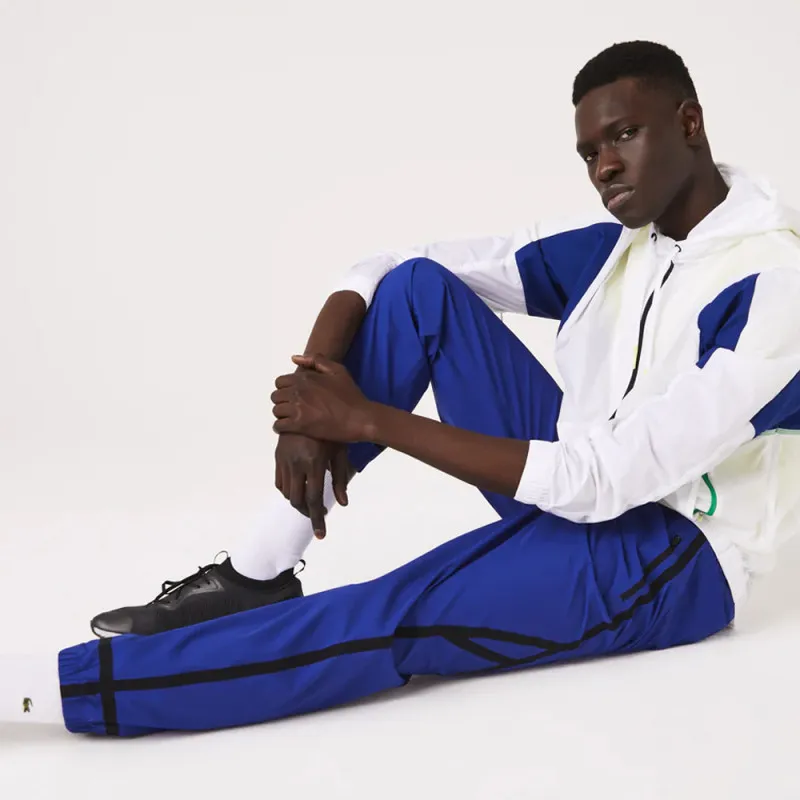 Pantalon de survêtement déperlant bleu bandes latérales noires Lacoste